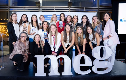 Ganadoras y finalistas del Premio Emprendedora del Año de MEG y WEDO posan junto al logotipo de MEG en Guatemala